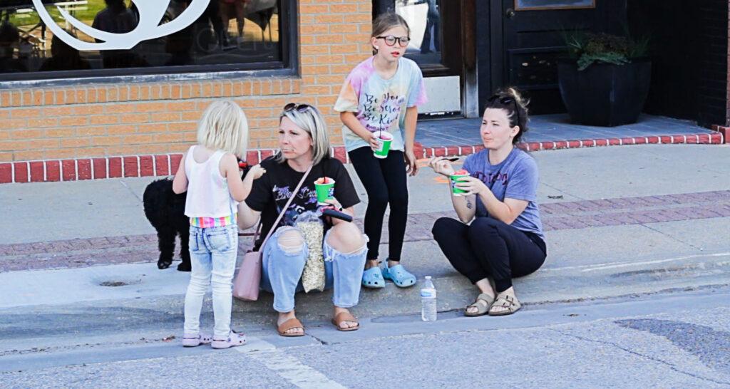 People on curb enjoying ice cream